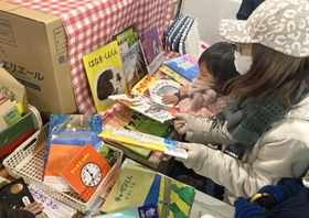 「ブックサンタ」から贈られた絵本を選ぶ女児＝神戸市北区南五葉１、インクルひろば