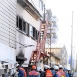 夜が明け、現場を調べる消防隊員ら＝神戸市長田区