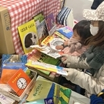 「ブックサンタ」から贈られた絵本を選ぶ女児＝神戸市北区南五葉１、インクルひろば