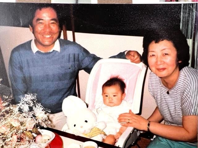 孫を挟んで笑みがこぼれる樽井千鶴子さん（右）と征四郎さん（村上さん提供）