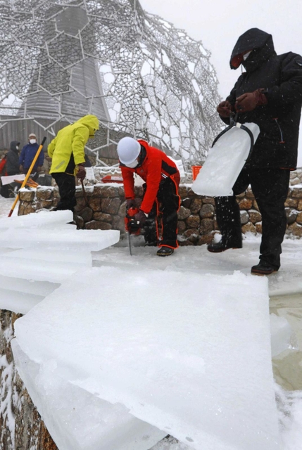 氷棚でできた天然の氷を運び出す職員ら＝２７日午前、神戸市灘区六甲山町