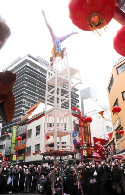 高く積み上げた椅子の上で倒立する雑技。観客ははらはらどきどき＝南京町広場