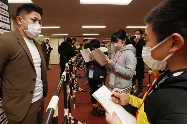 松永選手に試合の感想を尋ねる子ども記者たち＝神戸市須磨区緑台、ユニバー記念競技場