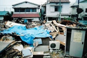 阪神・淡路大震災の被災地で、物置（右側）に残された１枚の張り紙。安否確認システム開発のきっかけとなった＝１９９５年１月、神戸市須磨区（インフォコム提供）