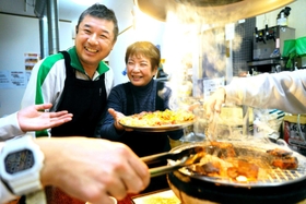 「立呑み処　冨月」を営む高利光さん（左）と妻悦子さん。今も店の２階で焼き肉を出す＝神戸市兵庫区新開地４