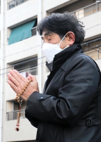 母千鶴子さんが亡くなった自宅跡地の前で手を合わせる村上幸生さん＝１７日午前７時、神戸市兵庫区松本通３