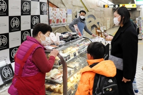 地下鉄の利用者に市場の食の魅力を伝える関係者＝神戸市兵庫区下沢通１