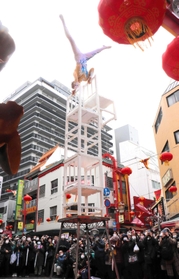 高く積み上げた椅子の上で倒立する雑技。観客ははらはらどきどき＝南京町広場