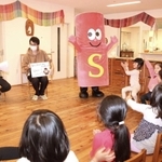 子どもに脳卒中について説明する（左から）尾原信行医師、藤原悟医師、ストローくん＝神戸市中央区港島南町２、杉の子保育園