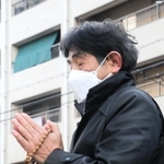 母千鶴子さんが亡くなった自宅跡地の前で手を合わせる村上幸生さん＝１７日午前７時、神戸市兵庫区松本通３