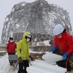 雪が降りしきる中、氷棚でできた天然の氷を切り出す職員ら＝２７日午前、神戸市灘区六甲山町、自然体感展望台「六甲枝垂れ」