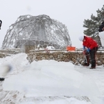 雪が降りしきる中、氷棚でできた天然の氷を切り出す職員ら＝２７日午前、神戸市灘区六甲山町、自然体感展望台「六甲枝垂れ」