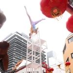 高く積み上げた椅子の上で倒立する雑技。観客ははらはらどきどき＝南京町広場