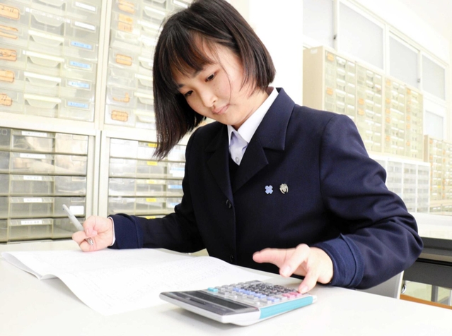 自己流の指の運び方で電卓をさばき、簿記を解く浜部希輝さん＝神戸市垂水区星陵台４