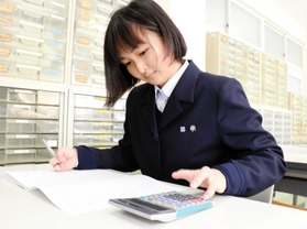 自己流の指の運び方で電卓をさばき、簿記を解く浜部希輝さん＝神戸市垂水区星陵台４