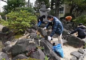 約９０年前に造成されたロックガーデン跡を再生させようと花の苗を植える久山敦さん（手前）ら＝神戸市東灘区魚崎北町８