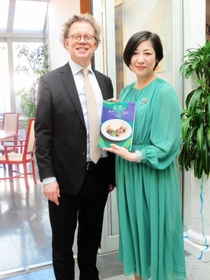 ペールエリック・ヘーグベリ駐日スウェーデン大使（左）とレシピ本をアピールする三田陽子さん＝東京都港区