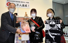 蓑豊館長（左）から記念品を受け取る田中芽依さん（中央）＝神戸市灘区