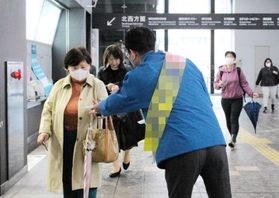 通勤時間帯に合わせて駅構内でチラシを配る候補者（画像の一部を加工しています）＝神戸市内（撮影・安藤真子）