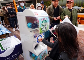 施設入園券やスイーツなどがもらえる「公園ガチャ」を楽しむ家族連れ＝神戸市中央区加納町６