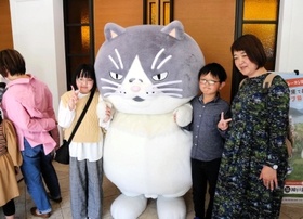 デブ猫マルと記念撮影する家族連れ