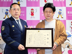 男の迷惑行為から女性を助け、葺合署の植田賢治署長（左）から感謝状を受け取った西谷信宏さん＝神戸市中央区吾妻通５