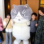 デブ猫マルと記念撮影する家族連れ