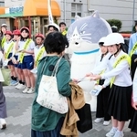 西代中、宮川小の生徒児童らと啓発グッズを配るマル（中央）＝長田神社前商店街