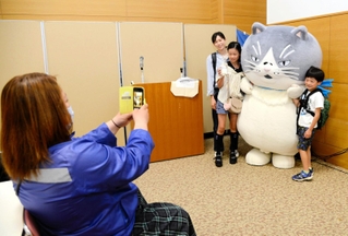 マルと記念撮影する参加者ら＝須磨パティオホール