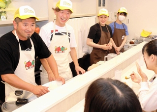 コウベリーズのメンバーにカレーを振る舞う（左から）平田敦彦さんと荻原裕二さん＝灘区永手町４