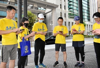 ランニング前にアプリでルートを確認する日本ふれパト協会のメンバー＝神戸市中央区江戸町