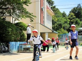 陸上大会の目玉「一輪車リレー」では、スタート地点で上級生が下級生をしっかりサポートしていた＝神戸市北区山田町藍那