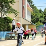 陸上大会の目玉「一輪車リレー」では、スタート地点で上級生が下級生をしっかりサポートしていた＝神戸市北区山田町藍那