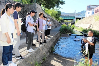 水難事故で５人が亡くなった都賀川で、水難事故を防ぐ方法を学ぶ参加者＝神戸市灘区船寺通１