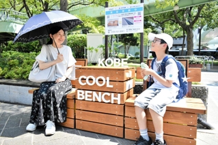 クールベンチで休憩する親子＝神戸市中央区加納町６