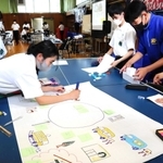 模造紙にどんどんアイデアを書き込んでいく唐櫃中の生徒たち＝神戸市北区唐櫃台４