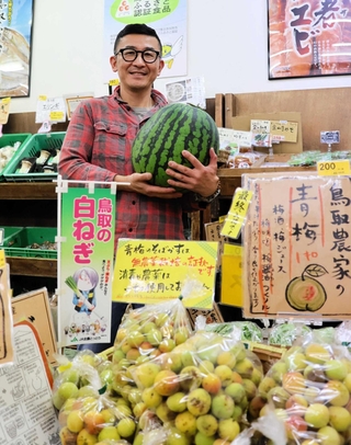 鳥取県産の野菜や果物を仕入れて販売する石原康臣さん。公的なアンテナショップとよく間違えられるという＝神戸市灘区篠原南町７