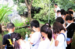 像に向かって手を合わせる児童ら＝神戸市須磨区友が丘８