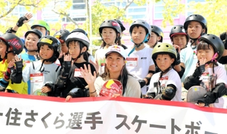 スケートボード体験教室に参加した小学生たちと笑顔で記念撮影に納まる四十住さくら選手（手前中央）＝神戸市東灘区向洋町中８、ジースケートパーク