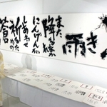 二重被爆者、山口さんの短歌をしたためた書を中心に紹介する西本直代さん＝東京都中央区銀座７、銀座第７ビルギャラリー