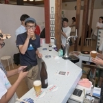 改装したロビーで風呂上がりの客らと談笑する松田悠さん（右）＝神戸市兵庫区東山町２