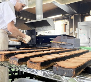 ゆるやかな谷型の曲げ台で瓦形にする＝神戸市中央区元町通６