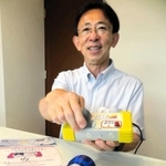 見守りシステムの新端末をＰＲする池上秀治さん。「高齢者が、能動的に取り組めることが大事」と話す＝神戸市東灘区