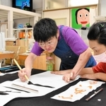 スタッフとともに書道に取り組む佐田かおりさん（左）。勢いのある筆運びが作品に生きる＝神戸市長田区川西通５