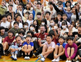 子どもたちに囲まれ、笑顔で記念撮影に応じるフアン・マタ選手＝こうべ小学校