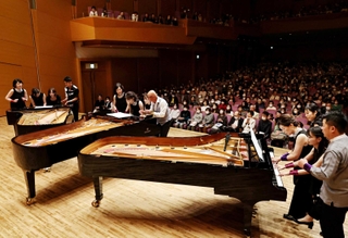 １２人でピアノ３台を同時に使って奏で、会場を沸かせた＝神戸新聞松方ホール（撮影・長嶺麻子）