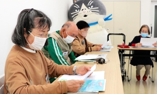 神戸新聞名谷中央専売所が開催する新聞朗読会に、デブ猫「マル」が登場した＝神戸市須磨区竜が台５、名谷南会館