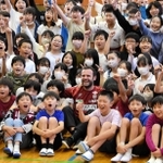 子どもたちに囲まれ、笑顔で記念撮影に応じるフアン・マタ選手＝こうべ小学校