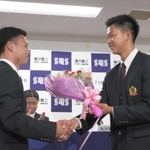 楽天から２位指名を受けた滝川二の坂井陽翔投手（右）。チームメートでバッテリーを組んでいた田村武琉選手から花束が贈られた＝２６日夜、神戸市西区春日台、滝川第二高校（撮影・風斗雅博）