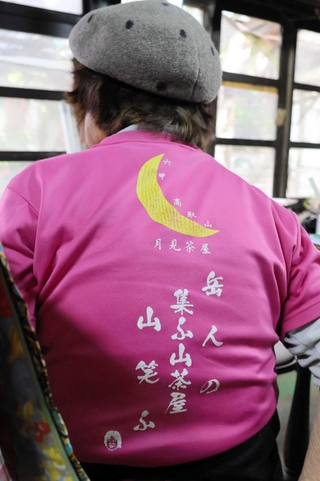 女将の川本眞智子さんが着るＴシャツには、山、茶屋を愛する言葉がこもった自作の句がプリントされている＝高取山